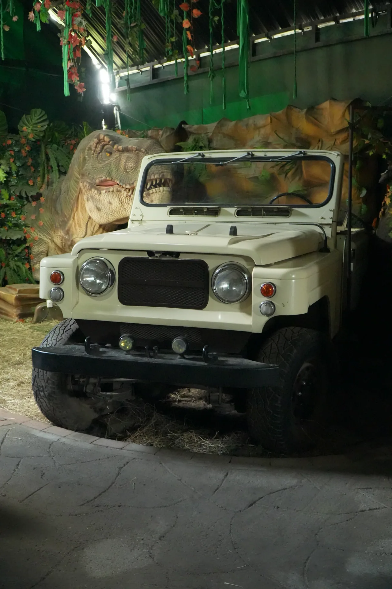 Vehicle in the Jurassic World scenery beside a dinosaur